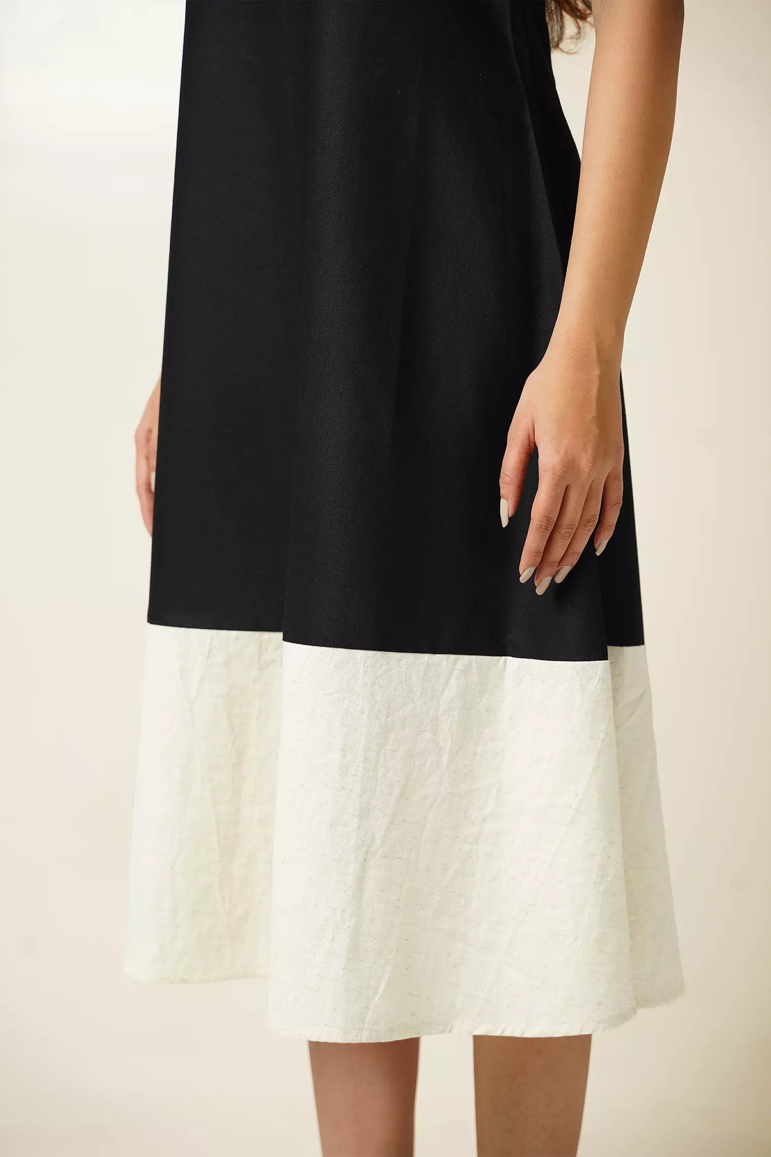 Close up view of Model wearing Odd Lama Berlin dress — black and cream straight cotton dress with halter neckline and razorback.