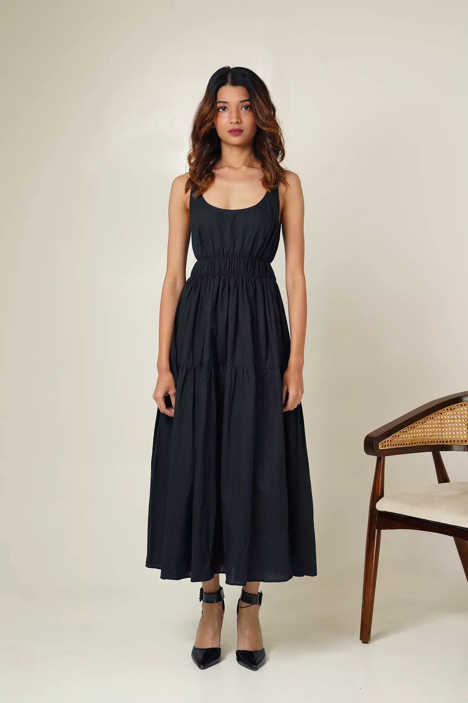 Front view of woman wearing the odd lama ankle length black tiered dress in pure cotton