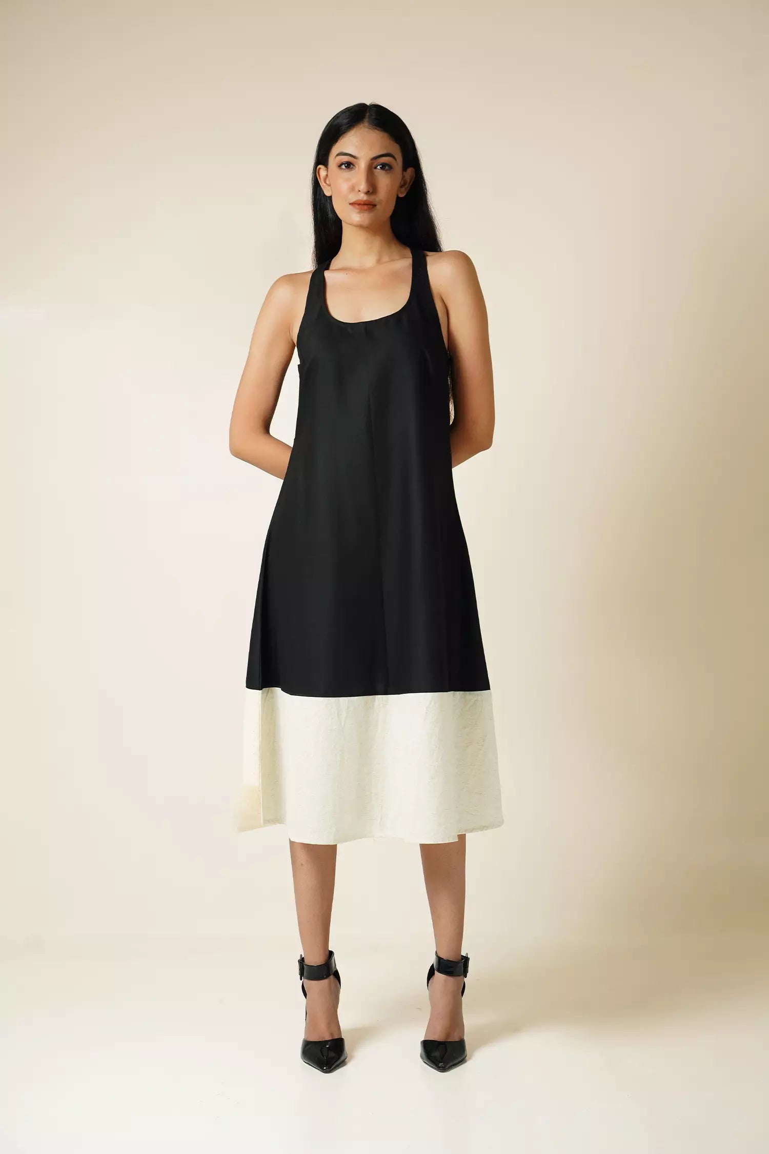 Front view of Model wearing Odd Lama Berlin dress — black and cream straight cotton dress with halter neckline and razorback.
