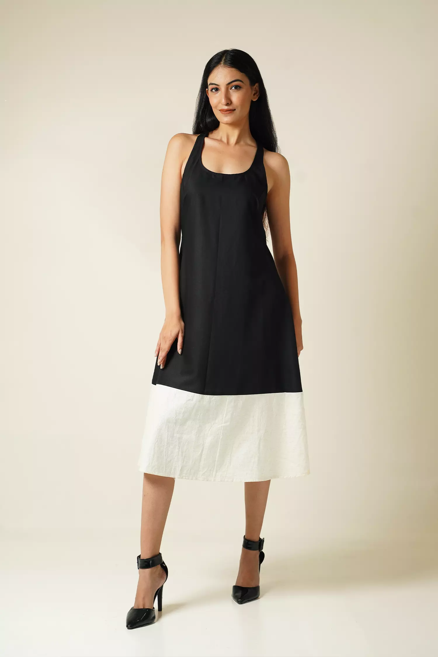 Front view of Model wearing Odd Lama Berlin dress — black and cream straight cotton dress with halter neckline and razorback.