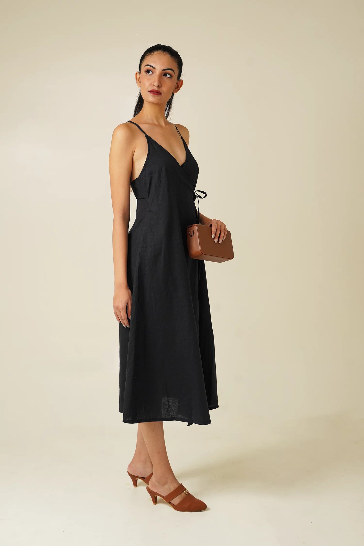 side view woman wearing Odd Lama black cotton wrap, sleeveless A-line dress