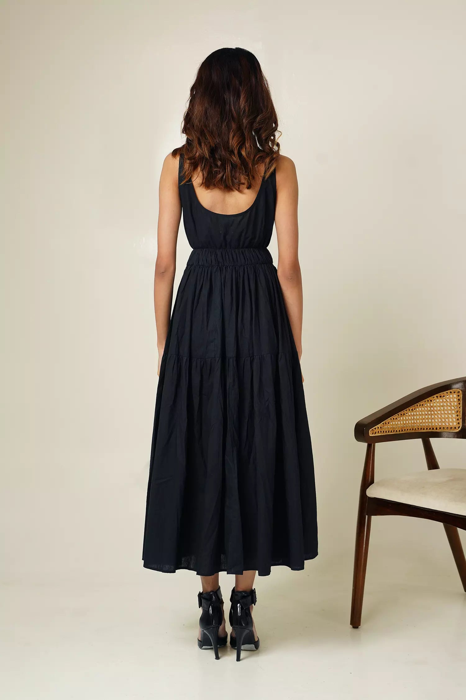 Back view of woman wearing the odd lama ankle length black tiered dress in pure cotton