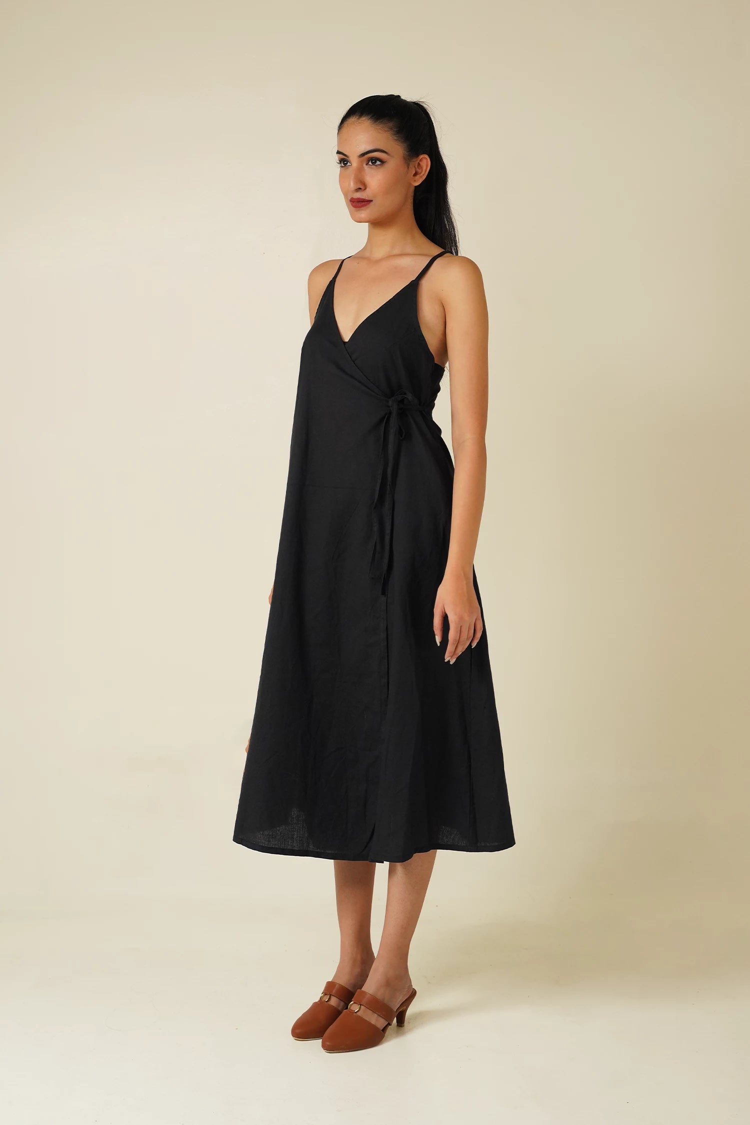 side view woman wearing Odd Lama black cotton wrap, sleeveless A-line dress 